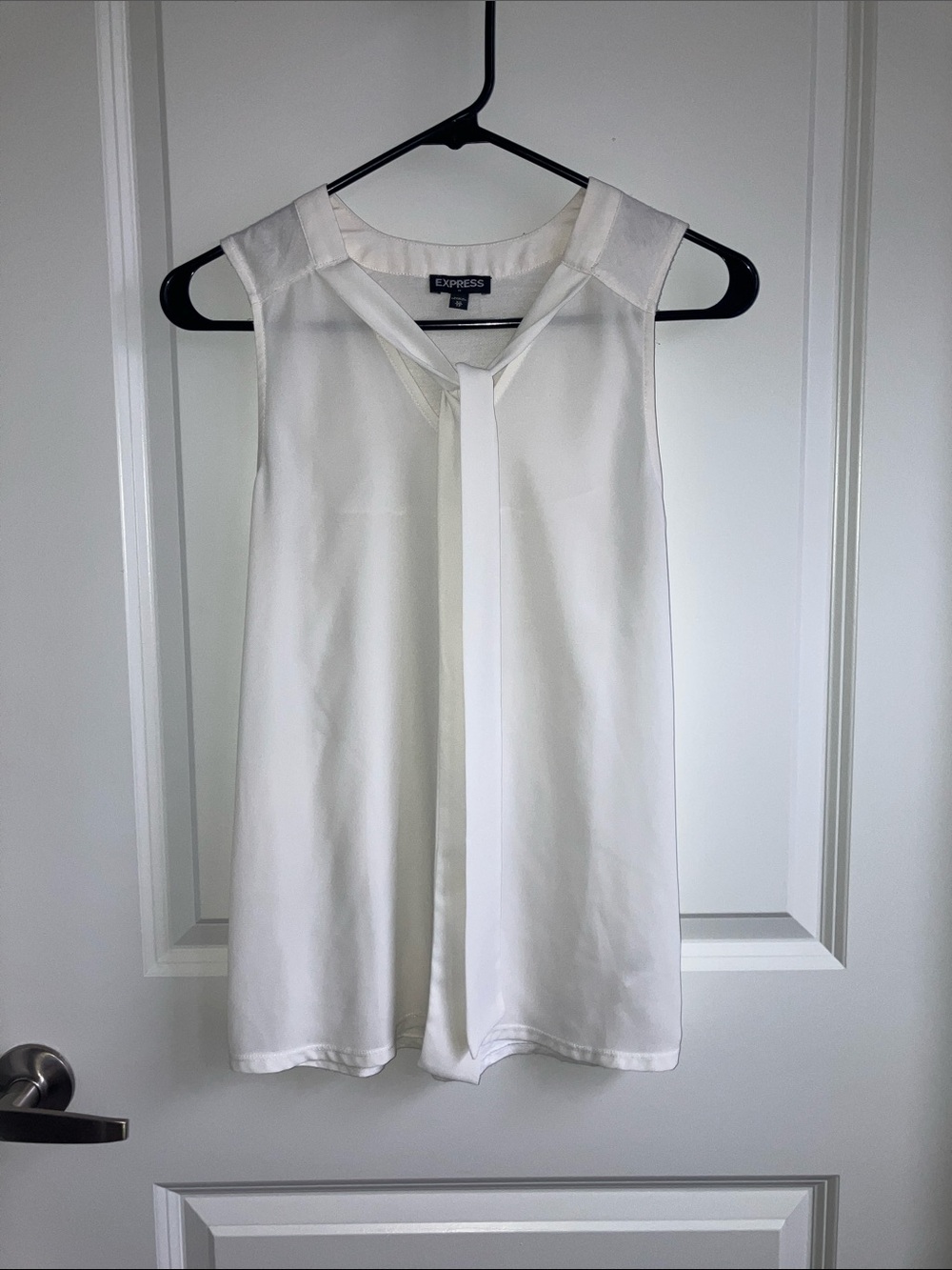 White sleeveless blouse with tie neck